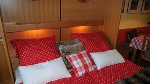 A bed with red polka dot bedding and a teddy bear. - Apartment, 300m to the ski slope, everything on site, gr. Leisure offer winter + summer (Rußbach)