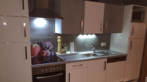 Una cocina con estufa, horno, fregadero y armarios.