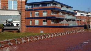 A multi-story building with a brick facade, a flat roof, and a series of balconies.