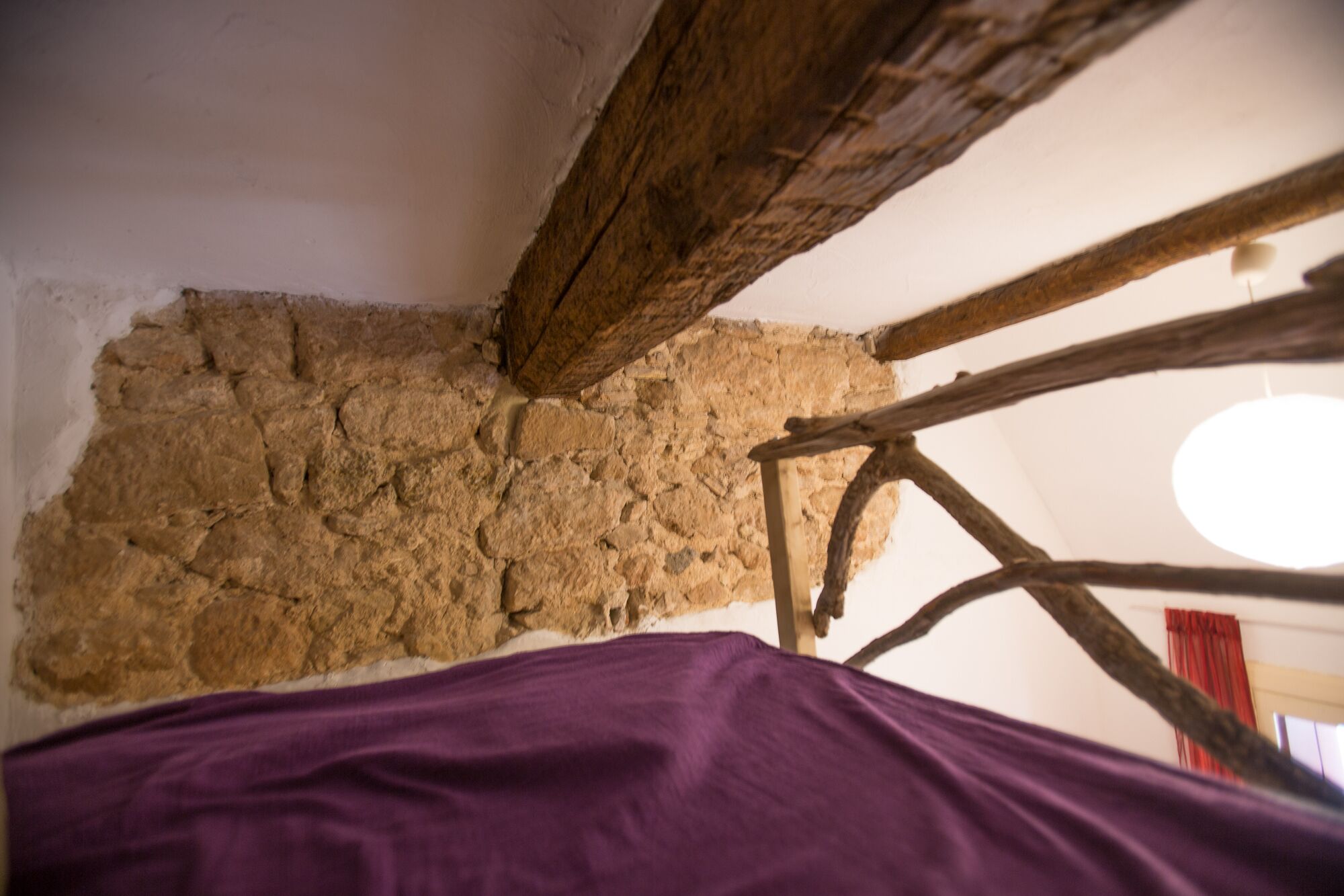Una habitación rústica con paredes de piedra vista y vigas de madera.