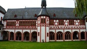 A historic building with a central tower, arched walkways, and a courtyard. - Apartment Marion Altenkirch (Rüdesheim am Rhein)
