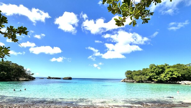 A beach with clear turquoise water, sandy shore, and lush greenery. - Shell House a unique bungalow with 14m pool and sea view (Cabrera Maria Trinidad Sanchez)