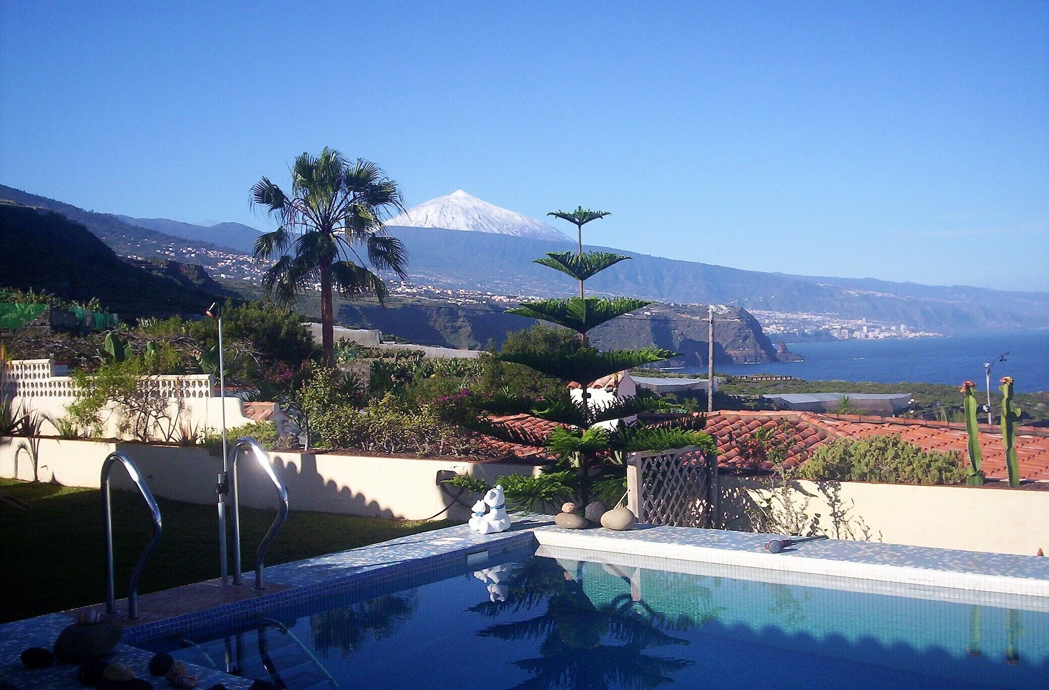 Piscina com vista para uma montanha e oceano.