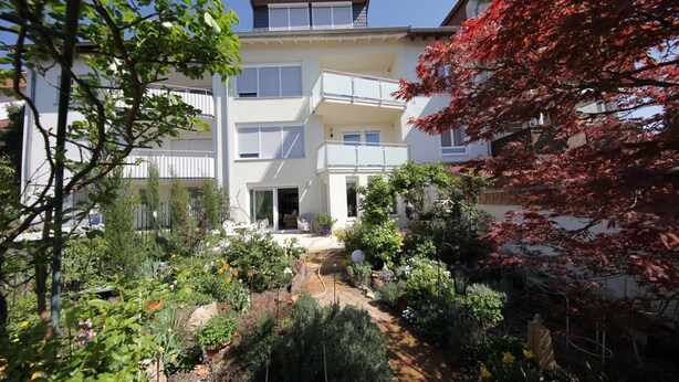 A multi-story residential building with balconies and a garden area with various plants and flowers. - quiet accommodation in a central location 2km to Heidelberg (Leimen)