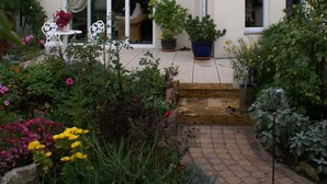 A two-story building with a balcony, a garden with potted plants, and a pathway leading to the entrance. - quiet accommodation in a central location 2km to Heidelberg (Leimen)