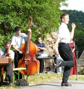 Een groep muzikanten treedt buiten op, met een cello en andere instrumenten.