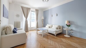 Un salon moderne avec un canapé, une table basse et une petite table d’appoint sur laquelle se trouve une lampe.
