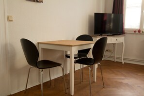 Cozy retreat with a flat-screen TV, table, and two chairs.