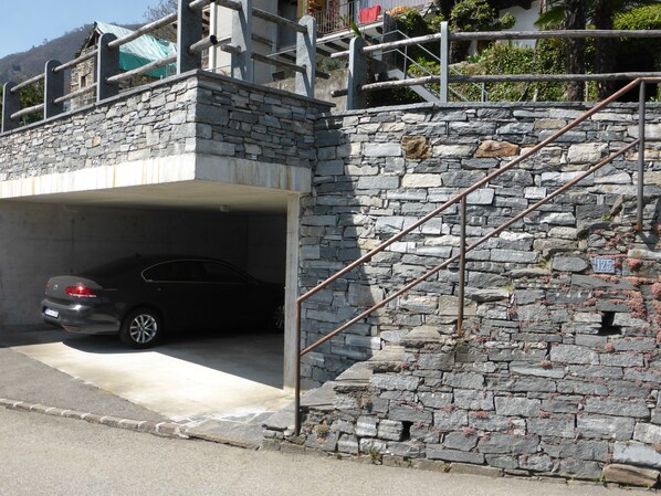 Una escalera de piedra que conduce a un coche estacionado bajo un edificio.