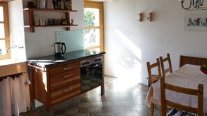 A kitchen with wooden cabinets, a stove, and a window.