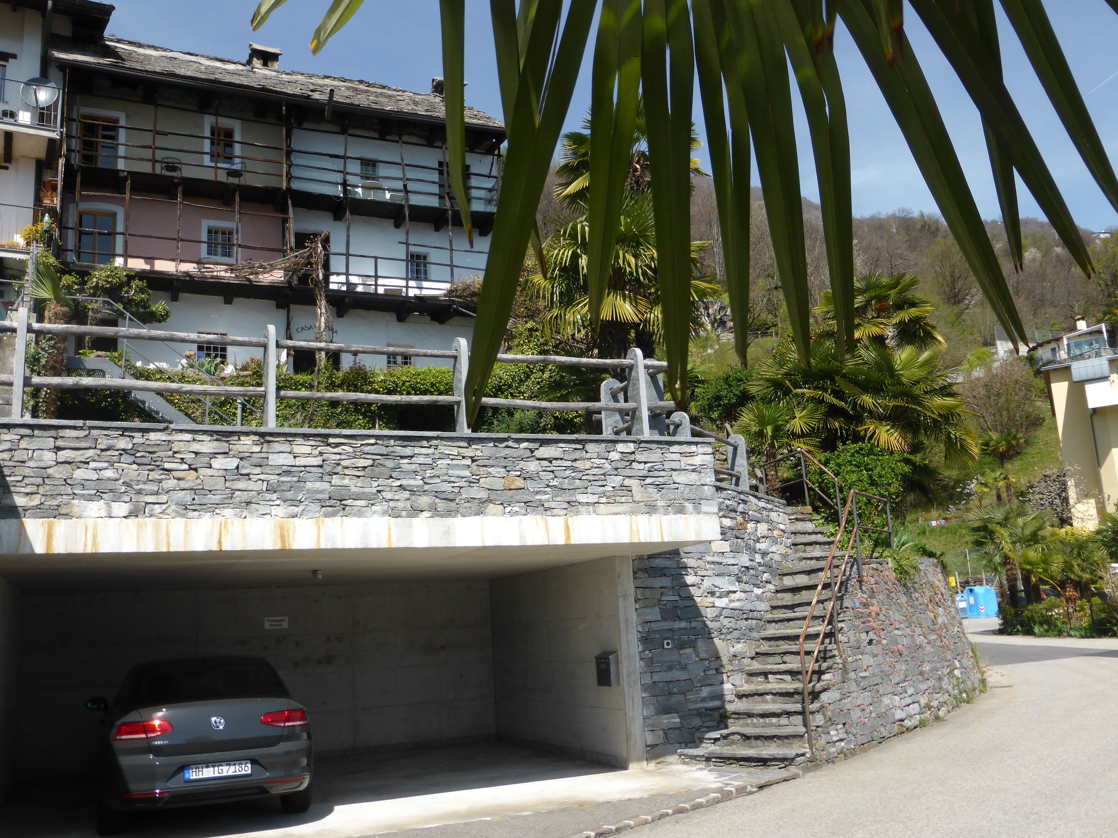 Un pont de pierre menant à un bâtiment sous lequel une voiture est garée.