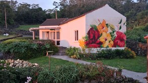 Una casa con jardín y un mural de flores en la pared.