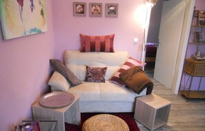 Relax in this inviting living space with a comfortable sofa, woven ottoman, and soft rug.