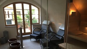 A sunlit room with a glass partition, wicker furniture, and a view of greenery outside. - Quiet living in the heart of Görlitz in elegant style (Görlitz)