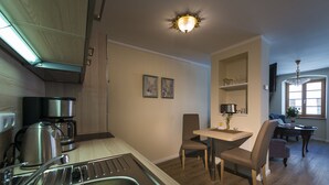 A modern kitchen with stainless steel appliances, a dining area with a table and chairs, and a chandelier. - Quiet living in the heart of Görlitz in elegant style (Görlitz)