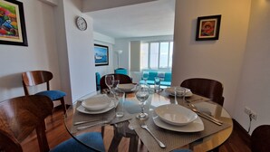 A dining area with a round glass table set for four, surrounded by wooden chairs. - MALECÓN BALTA: best location, friendly service, clean & comfortable, safe (Miraflores)