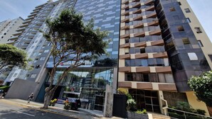 A modern hotel with a glass facade, multiple balconies, and a well-maintained entrance area. - MALECÓN BALTA: best location, friendly service, clean & comfortable, safe (Miraflores)