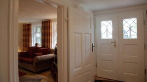 Ein Zimmer mit einer Couch, einer Tür mit Glasfenstern und einem Fenster.