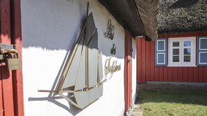 Ein Gebäude mit weißer Fassade und roter Tür. An der Wand befindet sich ein Schild mit der Aufschrift 'des Lichtkinder'.