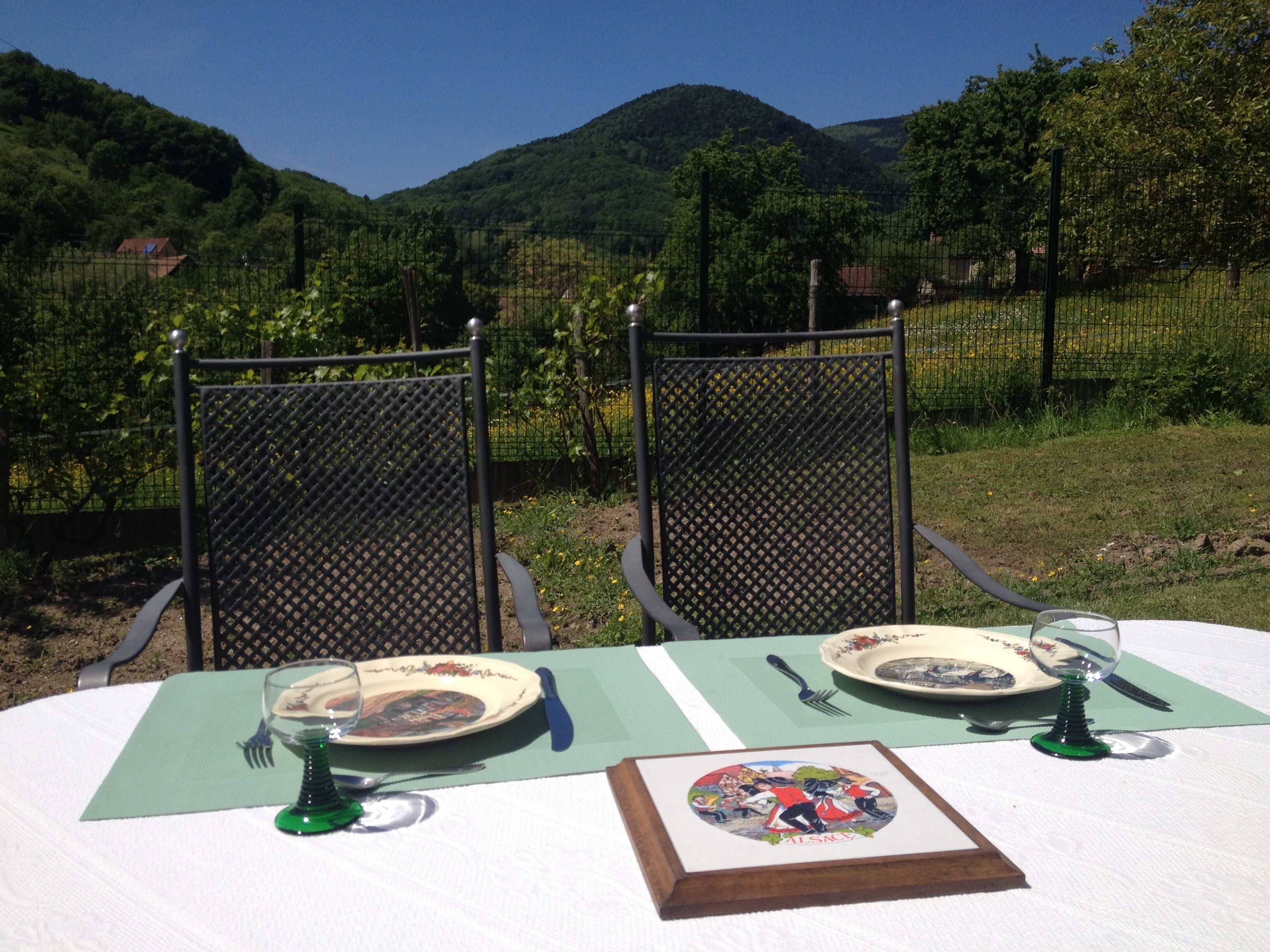 Une table dressée à l’extérieur, avec vue sur un paysage montagneux.