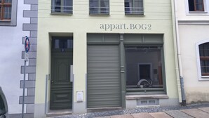 Un immeuble avec une enseigne indiquant « appart. BOG2 » au-dessus de l’entrée.