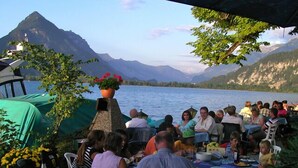 A group of people dining outdoors with a mountain view.