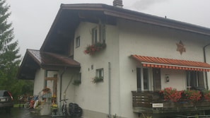 A two-story building with a sloped roof, a balcony with red flowers, and a wooden bench. - Active holiday, Family and children, Nature, Peace and relaxation, Sport (Brienz)
