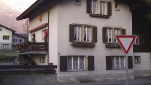 A two-story building with multiple windows, a balcony, and a traffic sign.