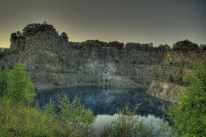 Eine natürliche Landschaft mit einem großen Gewässer, umgeben von felsigen Klippen und dichter Vegetation.