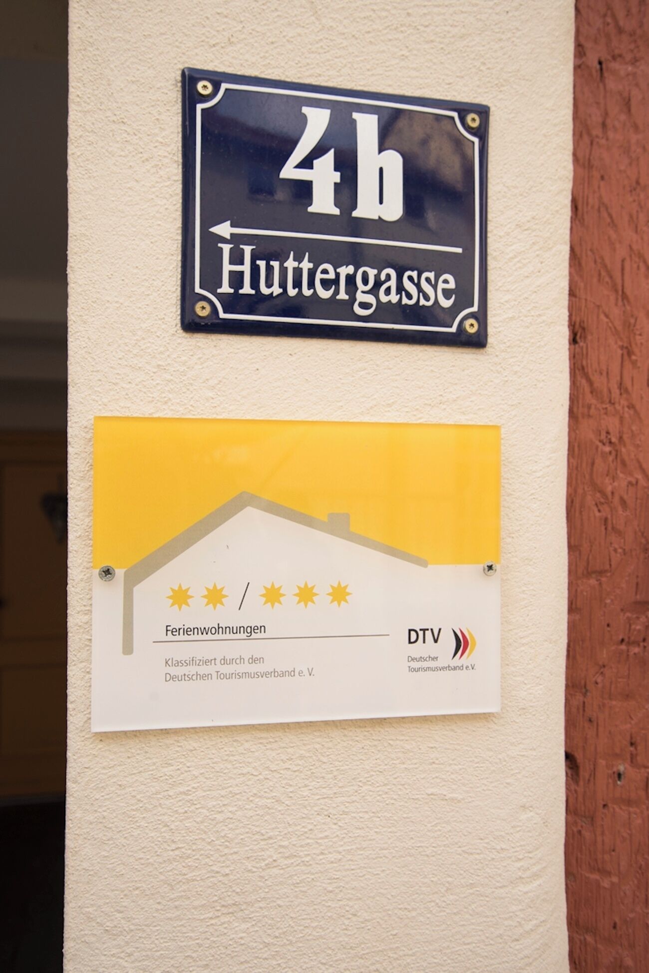 Et skilt, der viser '4h Huttergasse', og et vurderingskort fra 'Deutscher Tourismusverband e.V.'
