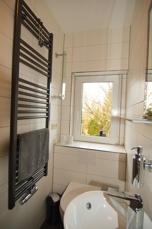 Bañera, secador de pelo, zapatillas y toallas