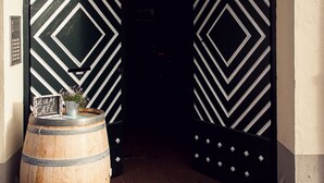Una puerta con diseños de franjas blancas y negras, un barril de madera y un letrero que dice "zum Cafe".