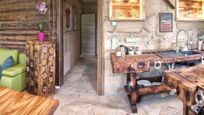 A rustic interior with a stone wall, wooden furniture, and a stone floor. - Apartment "Chiara" (Oybin)