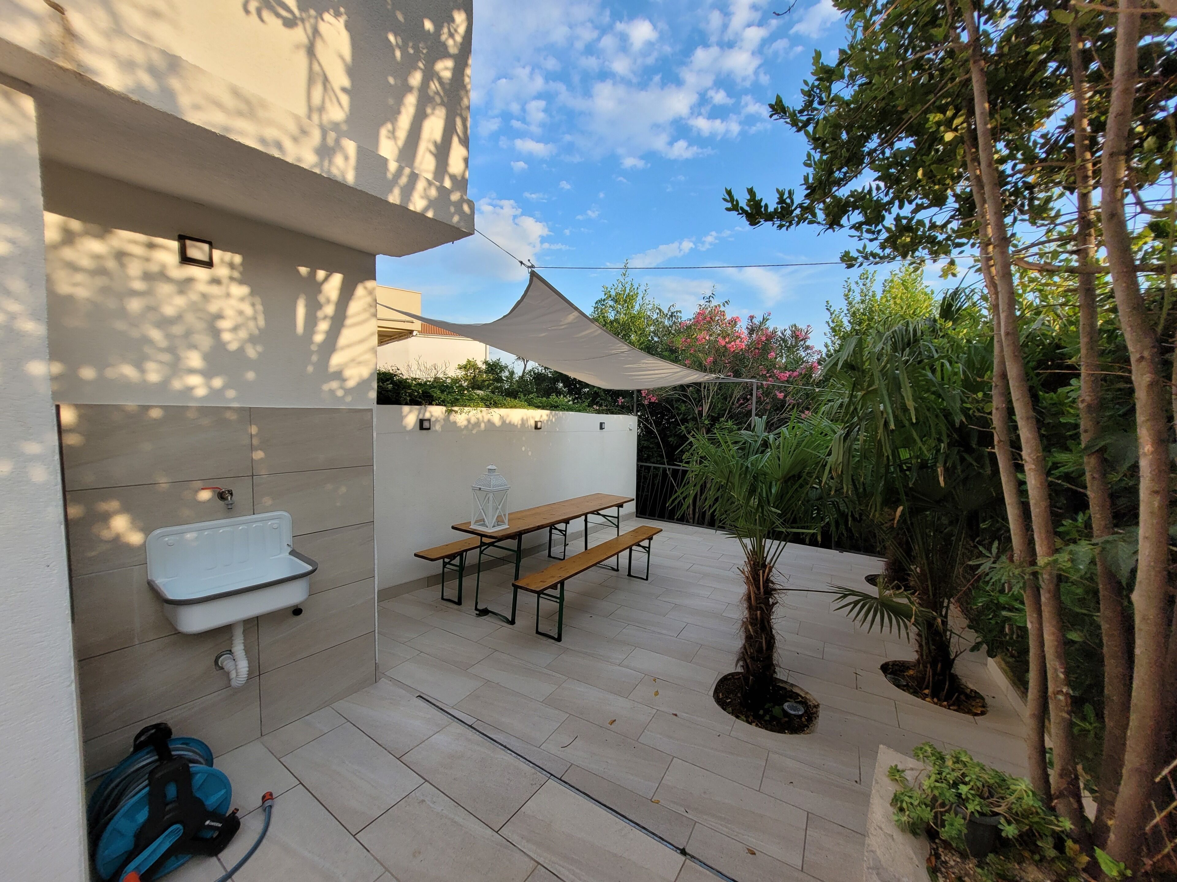 A patio with a table and chairs, a small sink, and a power outlet.