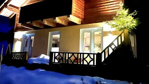 Eine Holzhütte mit einem Balkon und einer Treppe, die zum Eingang führt.