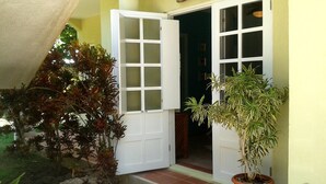 A building entrance with a 'WELCOME' sign, a potted plant, and a door leading inside.