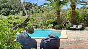 Un espace piscine avec des chaises longues et une terrasse en pierre.
