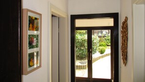 Ein Flur mit einer zur Außenseite führenden Tür, einem gerahmten Bild an der Wand und einer Wanddekoration.