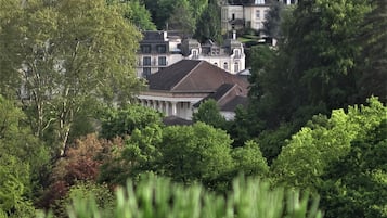 Un grand bâtiment historique doté d’une cour intérieure, entouré d’une végétation luxuriante.