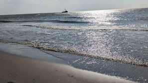 A beach with waves and a boat in the distance. - Top Vacation Villa, 120 sqm, Near the Beach, Quiet, 3 Bedrooms, 2 Bathrooms, Fireplace, Wi-Fi (Julianadorp aan Zee)