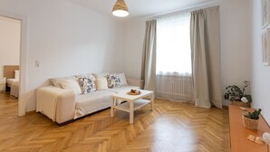 Een moderne woonkamer met een bank, een salontafel en een hanglamp.