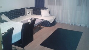 A small, cozy room with a bed, a desk, and a chair.