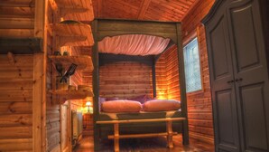 A cozy log cabin room with a bunk bed, wooden walls, a fur rug, and a window with blinds. - Quaint holiday home in the forests of Lapland by the river (Sorsele)