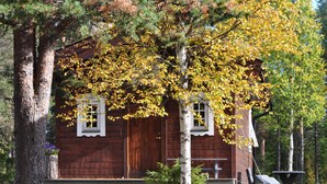 A rustic cabin with a wooden exterior, two windows, and a porch. - Quaint holiday home in the forests of Lapland by the river (Sorsele)
