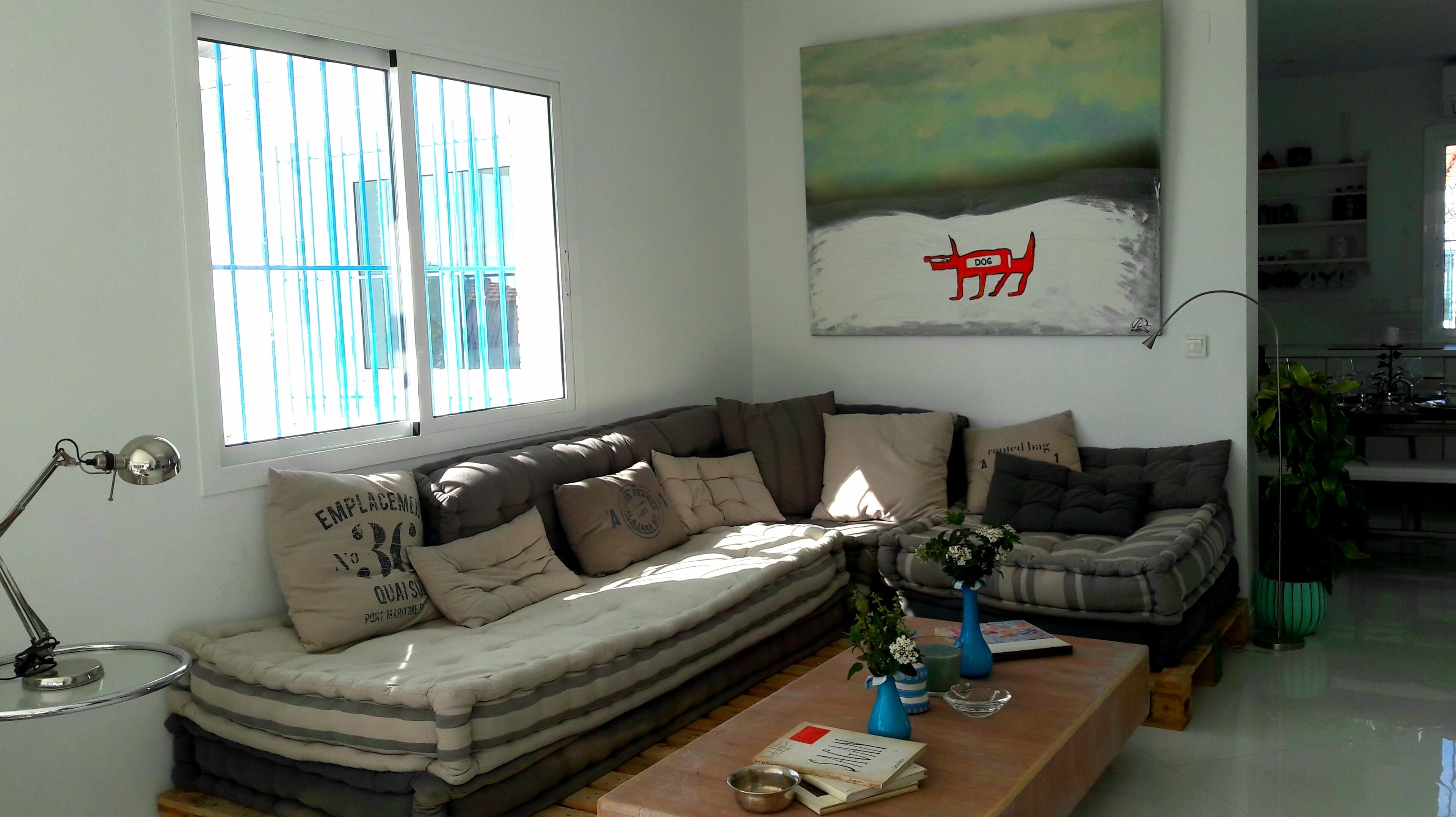 Ein Wohnzimmer mit einer Couch, einem Couchtisch und einem Gemälde an der Wand.