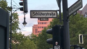 Straßenschilder für 'Schlüterstraße' und 'Kurtfürstendamm' mit Ampel und Straßenlaterne.