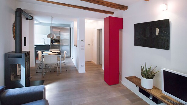 Una sala de estar moderna con chimenea, un comedor y una cocina al fondo.
