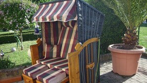 A striped beach chair with a canopy, positioned on a paved area with a potted plant nearby. - Holiday Apartment "Pharmacy" with Weinbergblick (Trittenheim)