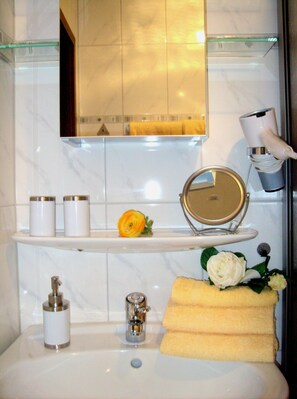 A bathroom with a white sink, a mirror, a towel rack, and a glass shelf with toiletries. - Holiday Apartment "altars" with Weinbergblick (Trittenheim)