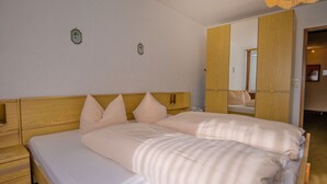 Un lit double avec une tête de lit en bois, deux tables de chevet et un miroir au mur.